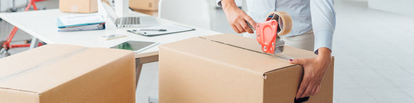 woman taping cardboard box