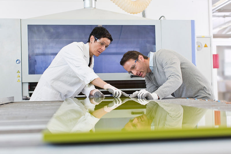 two engineers inspecting product assembly hot melt