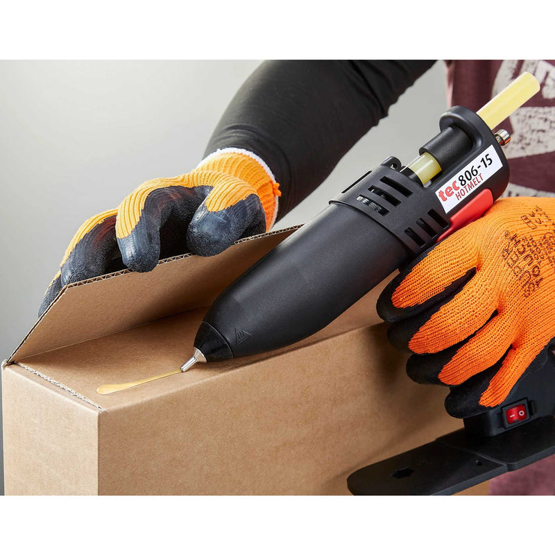 Worker sealing a cardboard box using a hot glue gun